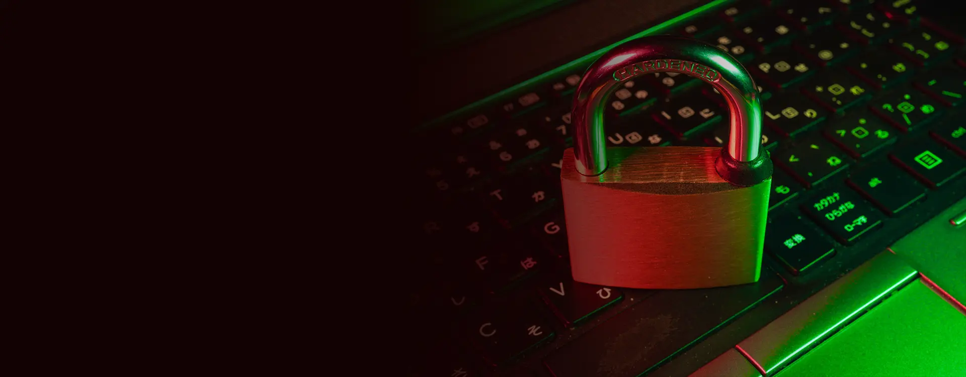 A padlock illuminated in red and green light rests on a computer keyboard, symbolizing cybersecurity and data protection.