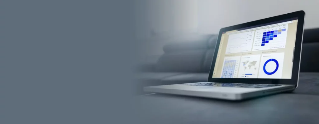 A sleek laptop displaying colorful data analytics charts and graphs on its screen, placed on a table in a modern living room environment.