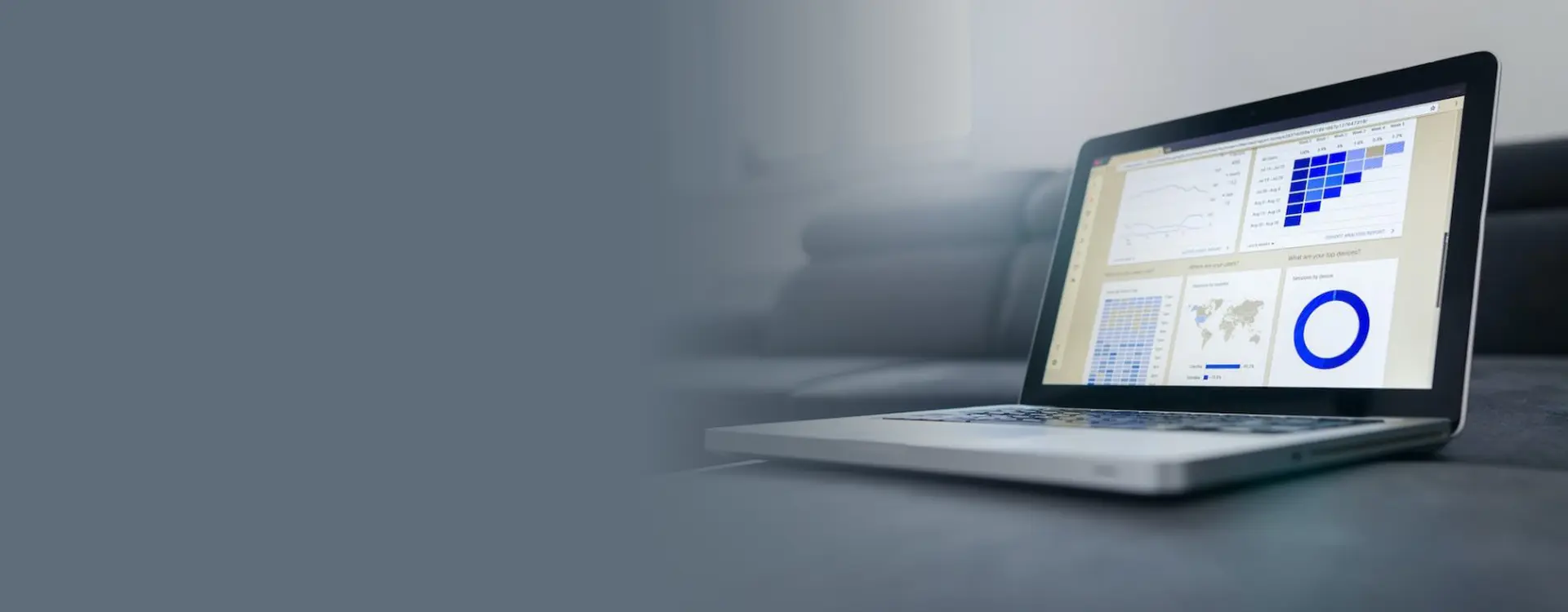 A sleek laptop displaying colorful data analytics charts and graphs on its screen, placed on a table in a modern living room environment.