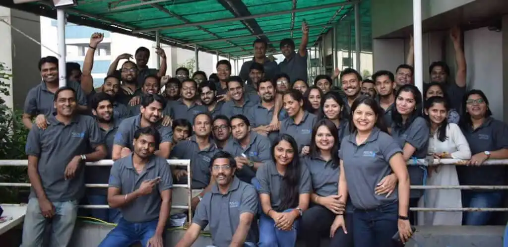 Focalworks team of smiling coworkers in matching company t-shirts posing together for a group photo.