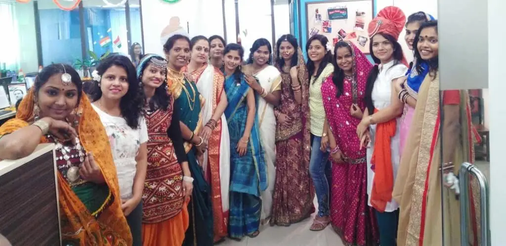 A group of women dressed in colorful traditional indian attire posing together for a photo at Focalworks office