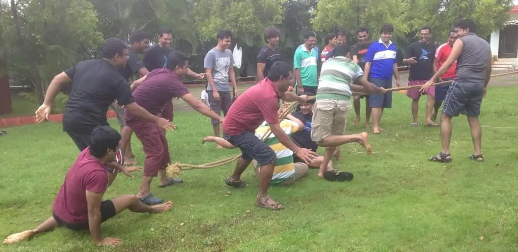 Focalworks team employee playing tug of war between two teams, with one team slipping in the midst.