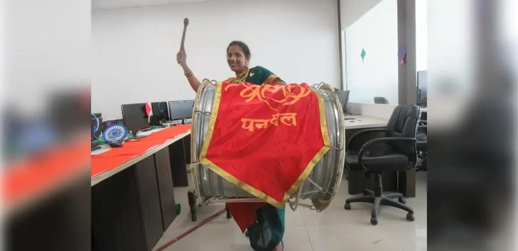 A woman plays a large drum to celebrate a festival at Focalworks office.