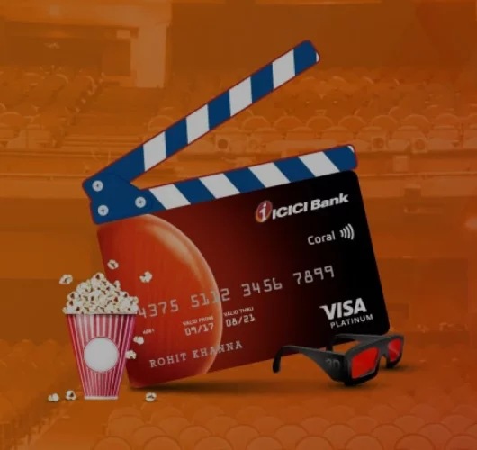 A cinema-themed image of an ICICI Bank Visa card styled as a clapperboard. Popcorn spills over, with 3D glasses nearby, set against a theater background.