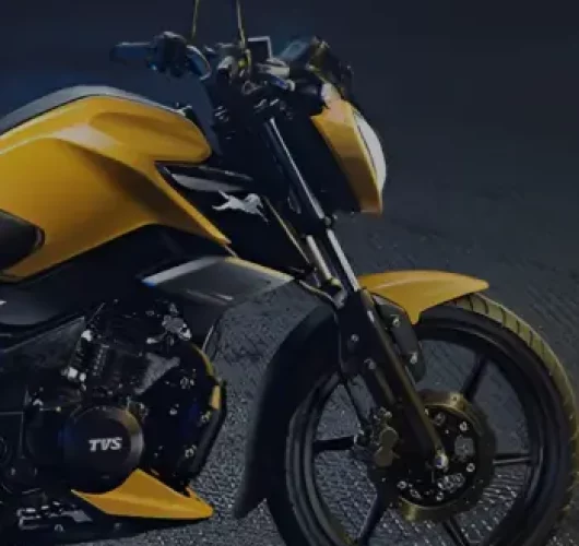A sleek yellow motorcycle is parked on a textured dark surface. The design is modern with sharp angles, suggesting speed and agility in a nighttime setting.